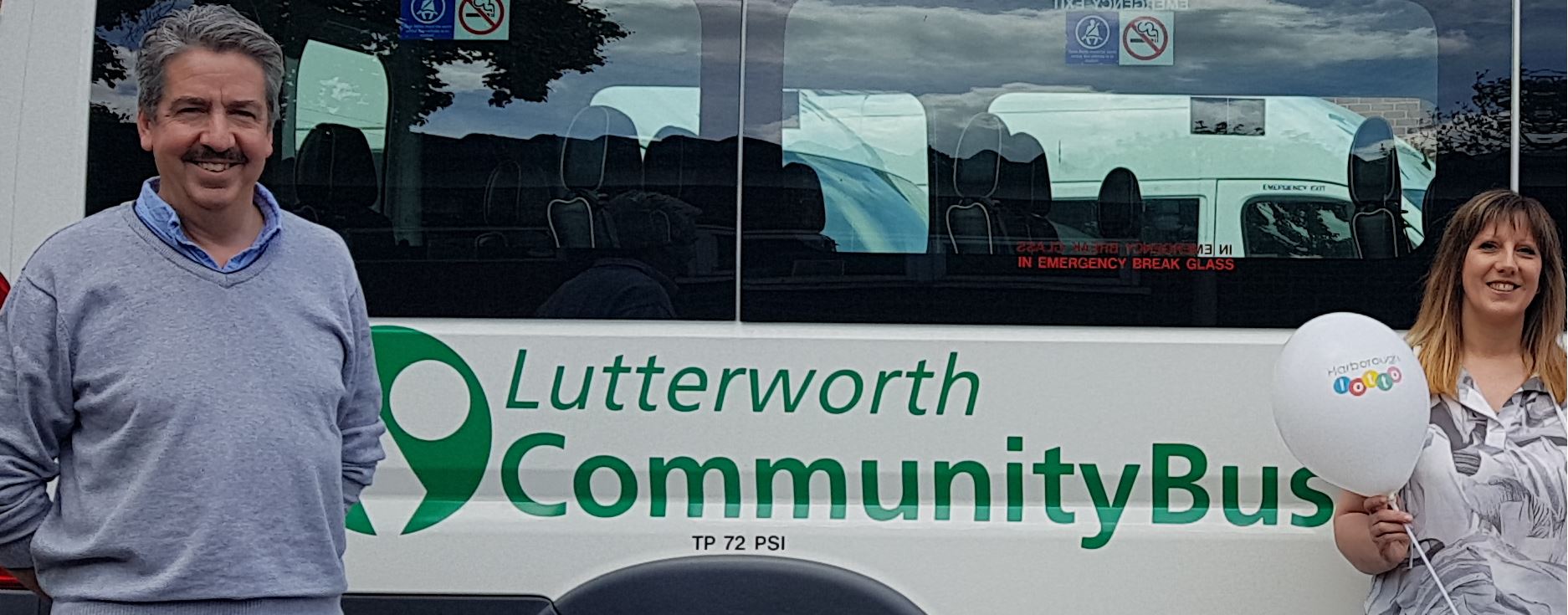 Roger and Amanda in front of one of the community buses